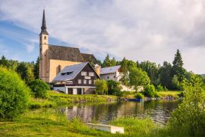 une église à côté d'une rivière avec une église dans l'établissement Marvelous lake view apartments - Jezerka Lipno, à Přední Výtoň