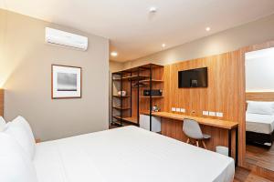 a hotel room with a bed and a tv at Slaviero Curitiba Aeroporto in São José dos Pinhais