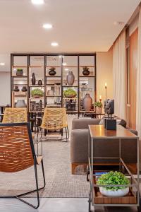 a living room with a couch and tables and chairs at Slaviero Curitiba Aeroporto in São José dos Pinhais