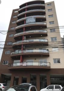 a apartment building with cars parked in front of it at Aloha III - El Palomar B&D in El Palomar