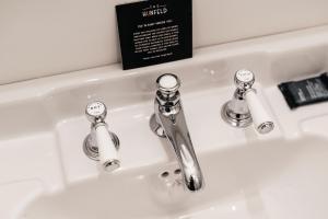 a bathroom sink with two faucets on it at The Hunfeld in Utrecht