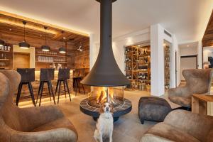 un perro sentado en una sala de estar con chimenea en Hotel Tabladel, en Colfosco