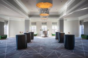 une salle de banquet avec des tables noires et un lustre dans l'établissement Kimpton Hotel Palomar Philadelphia, an IHG Hotel, à Philadelphie