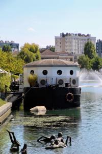 een groep mensen die in het water zwemmen bij een boot bij Logis Hôtel du Cirque Troyes centre historique in Troyes