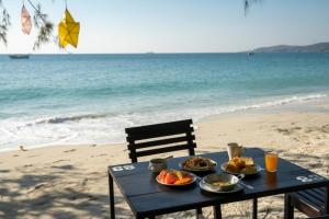 una mesa de picnic con comida en la playa en Avatara Resort, en Ko Samed