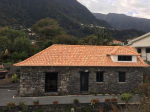 Casa de piedra con techo de baldosa naranja en Cottage Quinze, Contemporary designed cottage with Swimming pool, en Ponta Delgada