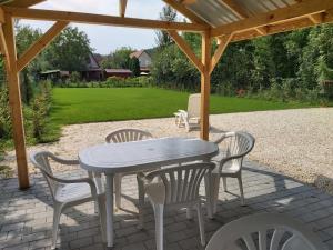 un patio con una mesa y sillas bajo un cenador en Fűzfa Vendégház, en Bogács