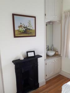 baño con lavabo y una foto en la pared en Conways B&B, en Claremorris