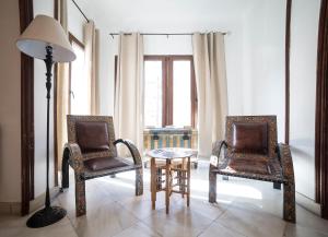 twee stoelen en een tafel en een lamp in een kamer bij Gala Placida 1923 in Granada