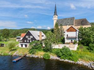 un bâtiment avec une église à côté d'une rivière dans l'établissement Marvelous lake view apartments - Jezerka Lipno, à Přední Výtoň