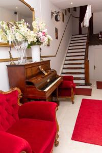 uma sala de estar com um piano e cadeiras vermelhas em L'ambassadeur - Colmar centre em Colmar