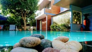 uma pilha de pedras sentadas ao lado de uma piscina em Mui Ne Alena Hotel em Phan Thiet