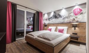 una camera con un letto e una parete con un quadro di Alpenchalet Montafon a Gaschurn