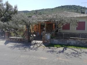 uma casa com uma cerca e árvores em frente em Villa San Gavino em Budoni