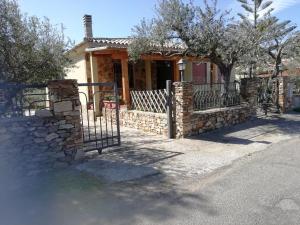 uma casa com uma cerca de pedra e um portão em Villa San Gavino em Budoni