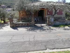 uma casa com uma cerca e uma árvore em frente em Villa San Gavino em Budoni