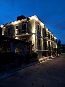 un edificio blanco con luces en el costado en Hotel Galaxidi, en Galaxidhion