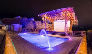 - une grande piscine avec un kiosque la nuit dans l'établissement Prana, à San Gil