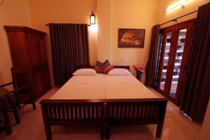 una habitación con una mesa y una cama en ella en Nirrvaan homestay, en Varkala