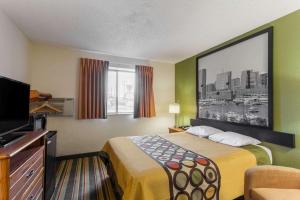 Super 8 by Wyndham College Park Wash DC Area في كوليدج بارك: غرفة فندقية بسرير وتلفزيون بشاشة مسطحة