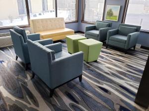 una sala d'attesa con sedie, tavoli e finestre di Days Inn & Suites by Wyndham Merrillville a Merrillville