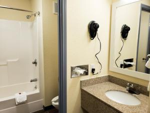 bagno con lavandino, specchio e servizi igienici di Days Inn & Suites by Wyndham Merrillville a Merrillville