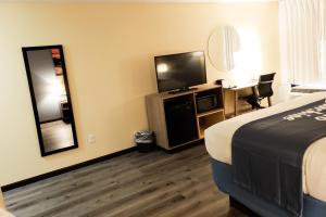 una camera con letto e TV a schermo piatto di Days Inn & Suites by Wyndham Merrillville a Merrillville