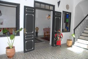 una habitación con una puerta abierta con una persona de pie en la planta en Riad Tingis, en Tánger