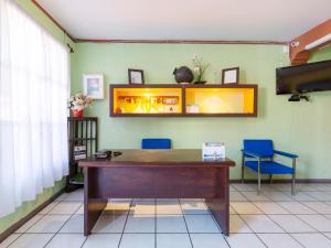 een kamer met een bureau en 2 blauwe stoelen bij Hotel Posada San Rafael in Oaxaca City