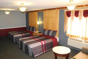 ein Hotelzimmer mit 2 Betten und einem Tisch in der Unterkunft Liberty Inn Absecon Atlantic City in Galloway