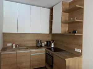 a kitchen with white cabinets and a sink at Apartmán Jeleň Chopok Juh-Trangoška in Tale