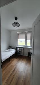 una camera con un letto e due finestre di Apartament Północna przy Suntago, Deepspot a Mszczonów