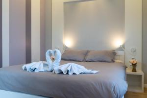 a bed with a towel animal on top of it at Apartments Slana Oaza in Tuzla