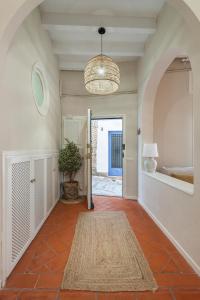 a hallway with a potted plant and a chandelier at La Casita - centro histórico y playa in Sitges