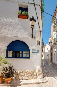 a white building with a blue door and a window at La Casita - centro histórico y playa in Sitges