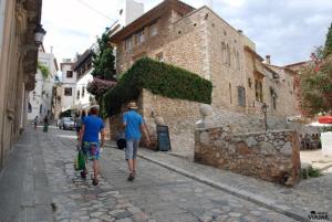 a couple of people walking down a street at La Casita - centro histórico y playa in Sitges