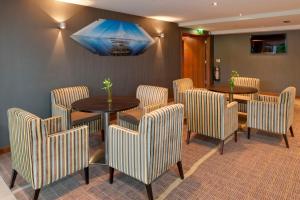 een eetkamer met stoelen en een tafel en een tafel bij Holiday Inn Bristol City Centre, an IHG Hotel in Bristol