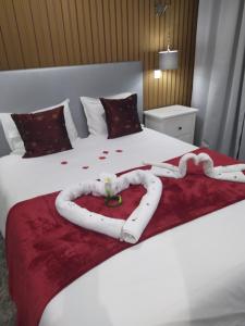 a white bed with a heart made out of roses at Casa da Leninha in Nazaré