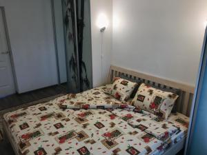 a bed with a quilt and pillows in a bedroom at Fine Apartment in Jelgava