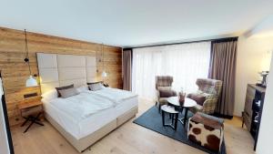 - une chambre avec un lit, une table et des chaises dans l'établissement Walliserhof Grand-Hotel & Spa Relais & Châteaux, à Saas-Fee