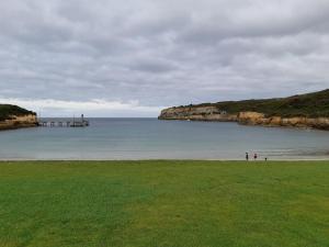 - une plage avec une jetée et des personnes sur l'eau dans l'établissement Port Central No 2, à Port Campbell