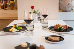 uma mesa com pratos de comida e copos de vinho em Hotel Rössli Gourmet & Spa em Weggis