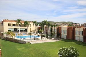 ein Apartment mit einem großen Garten mit einem Pool in der Unterkunft Holiday Inn Hermosillo, an IHG Hotel in Hermosillo