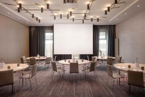 sala konferencyjna ze stołami i krzesłami oraz ekranem projekcyjnym w obiekcie Holiday Inn Hamburg - City Nord, an IHG Hotel w mieście Hamburg