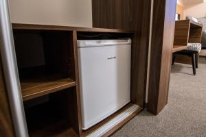 a small white refrigerator in a wooden cabinet at Pension Bed&Breakfast in Kutná Hora