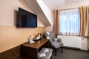 a room with a desk and chairs and a tv at Pension Bed&Breakfast in Kutná Hora