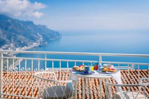 a table with two plates of food on a balcony at Casa Dolce Casa in Ravello