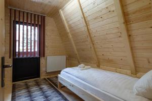 - une chambre avec un lit dans une pièce en bois dans l'établissement Centrul de Echitatie Poiana Brasov, à Poiana Brasov