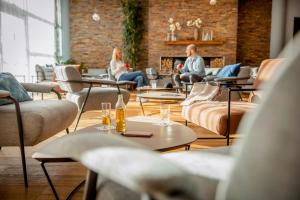 un groupe de personnes assises dans une salle avec des tables et des chaises dans l'établissement TUI BLUE Fieberbrunn, à Fieberbrunn