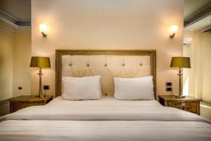 una camera da letto con un grande letto bianco con due lampade di The Country Lodge Hotel a Freetown